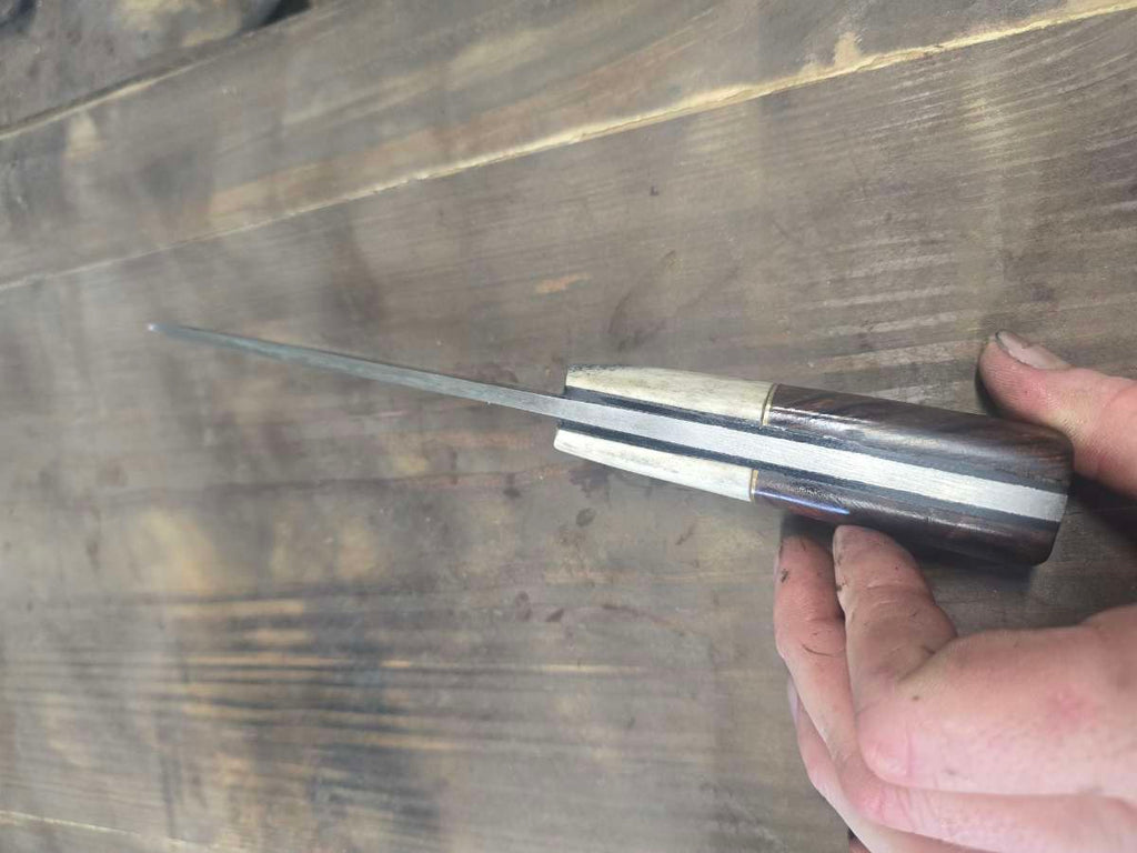 Spine view of 440C skinner showing black G10 inlay and brass divider