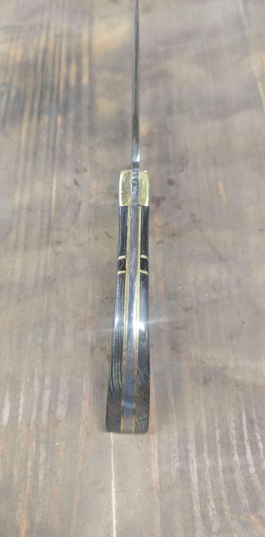 Spine view showing the skinning knife handle and brass inlay