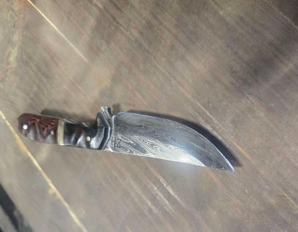 Alabama Damascus knife with desert ironwood and red linen Micarta handle, brass and nickel dividers and white G10 inlay — angled view