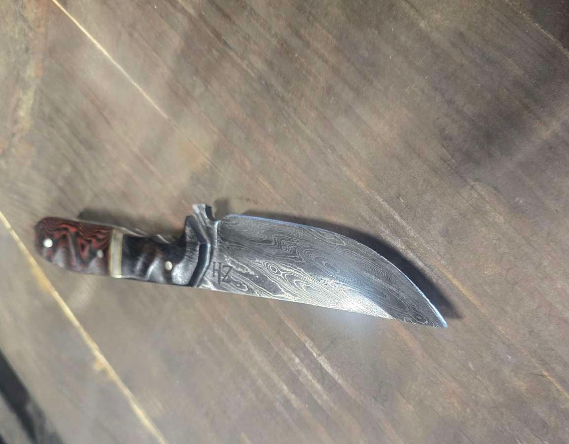 Alabama Damascus knife with desert ironwood and red linen Micarta handle, brass and nickel dividers and white G10 inlay — angled view