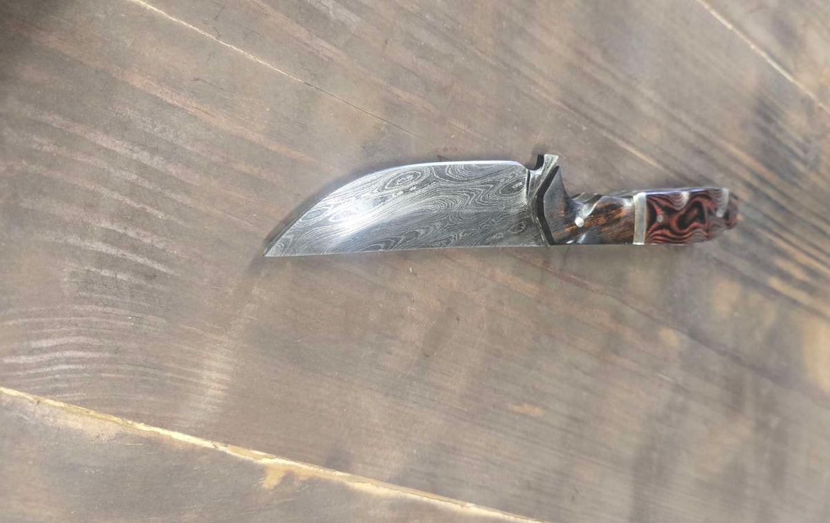 Alabama Damascus knife with desert ironwood and red linen Micarta handle, brass and nickel dividers and white G10 inlay — angled view
